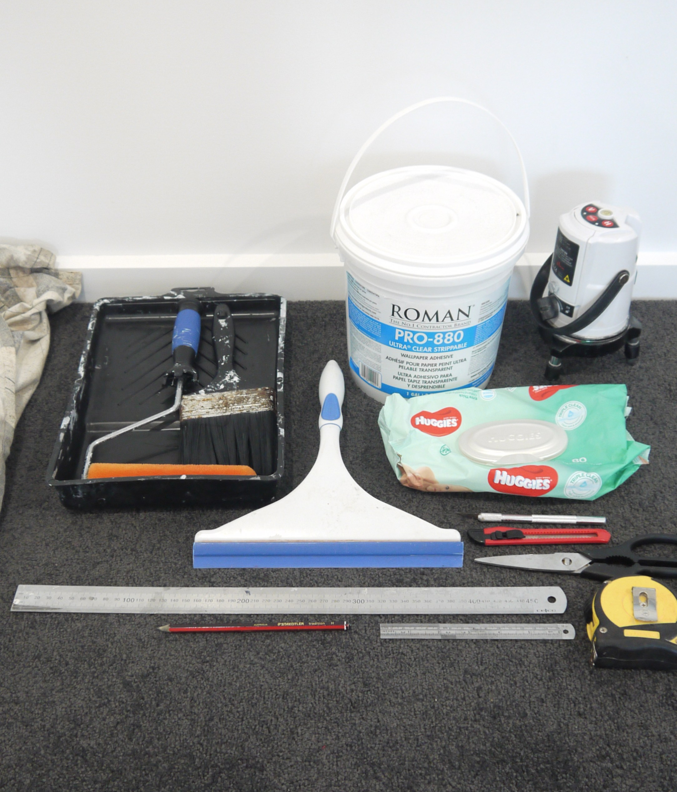 All the supplies needed to complete a vinyl heavy duty wallpaper wall covering installation. Heavy duty adhesive, laser level, steel ruler, stanley knife, tape measure, squeegie, baby wipes, paint roller and brush. 